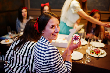 Fabulous girls posing with cupcakes in the restaurant at the bachelorette party.