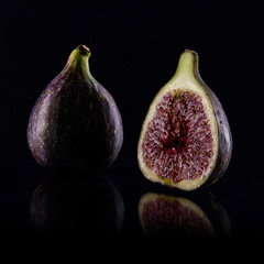Fresh figs. Fruit with half  isolated on black background.