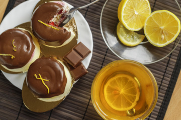Cake with a cup of tea on a dark wooden background.Dessert of cottage cheese in chocolate glaze