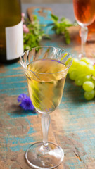 Cold summer wines, white and rose, served in beautiful glasses on terrace in cafe with romantic flowers