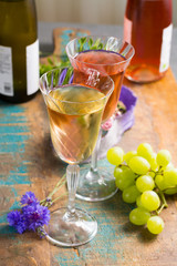 Cold summer wines, white and rose, served in beautiful glasses on terrace in cafe with romantic flowers