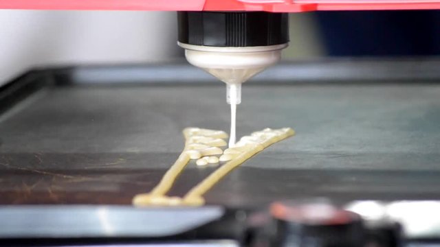 3d printer for liquid dough. 3D printer printing pancakes with liquid dough different shapes close-up. Modern additive technologies 4.0 industrial revolution