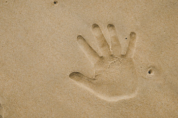 Copy space of hand finger print on sand beach texture background.