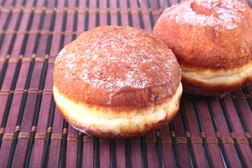 Homemade Doughnuts with Jelly filled and powdered sugar on Bamboo tablecloth. Selective focus.