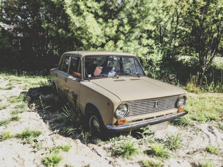 An old car car wasting in the outdoors