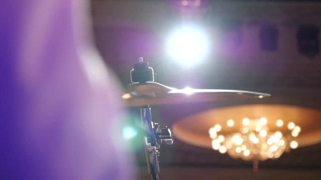 closeup view of a hi hat cymbal played with a drumstick. live concert Slow motion