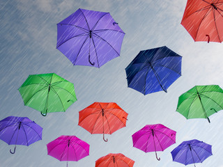 Umbrellas against grey sky.  With rain effect.