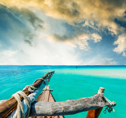 Fototapeta premium amazing view of blue sky and turquiose ocean from wooden african boat