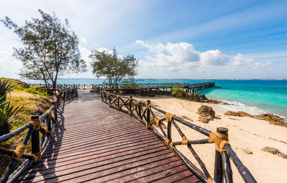 beautiful exotic landscape with wooden pier leading to the blue ocean in Africa