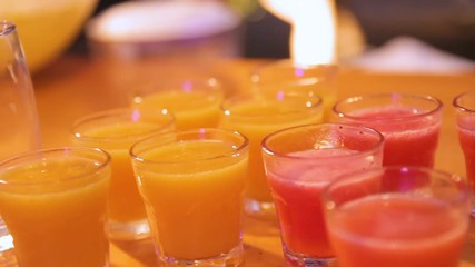 Many shot glasses with alcohol and citrus fruits juice