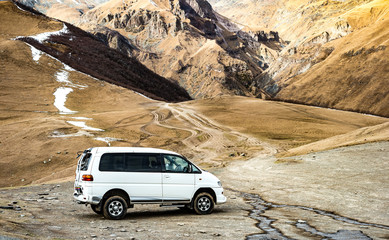 White van ready to travel through steep trail in Kazbegi, Stepantsminda, Georgia