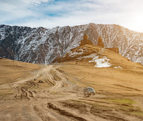 Cars coming to the lonely chruch lost in the mountains in Georgia