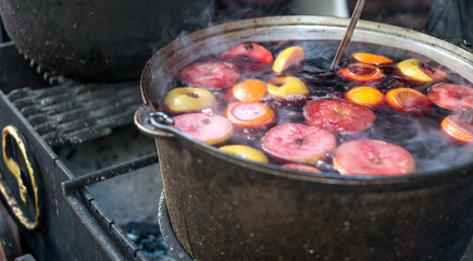 Hot gluhwein or mulled wine in a cauldron at fair, local treat, warm and spicy