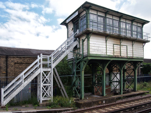 old british railway signal box with wooden white planks on an iron frame with white steps and track visible in the foreground taken in Canterbury kent