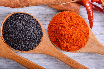 Sweet basil seeds and paprika powder in wood spoon