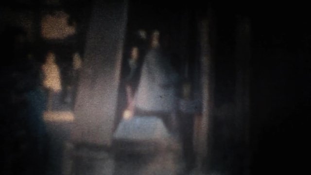Watching frames of a Super 8 mm vintage amateur film, on the tiny screen of an editing machine (a moviola, a device that allows viewing a reel at a reduced speed). Generic holiday scenes.

