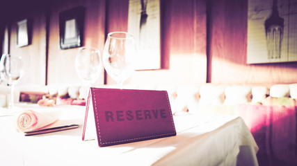 Reservation sign card in the luxury restaurant. Reserved table in at the cafe.