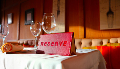 Reservation sign card in the luxury restaurant. Reserved table in at the cafe.