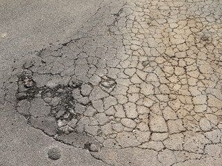 Old worn and cracked asphalt with cracks