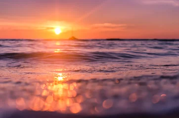 Gordijnen Blur tropical sunset beach with bokeh sun light wave abstract background. © tonktiti