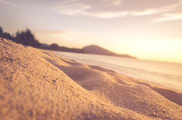 Tilt-shift blur tropical sunset sand beach with bokeh sun light abstract background.
