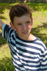 young smiling boy with a fashionable hairstyle on the walk