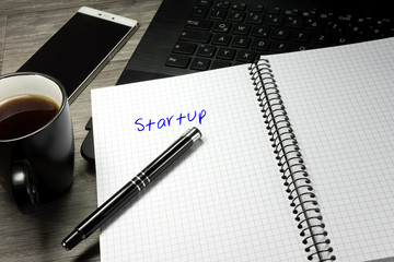 Ein Büro und Notizblock mit dem Wort Startup