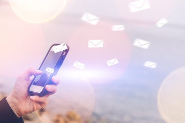 Woman hand using smart phone double exposure email fly draw bokeh at beach .Business economic technology working connect and travel adventure summer holiday concept.