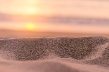 Fototapeta na wymiar Blur tropical sunset beach with bokeh sun light sand abstract background.