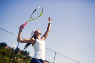 Fototapeta na wymiar Beautiful female tennis player serving
