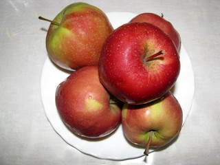 Red apples on a white plate.