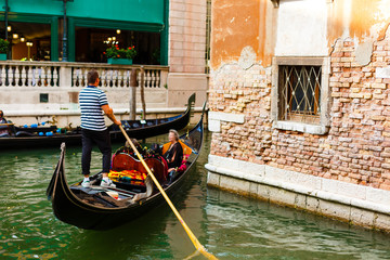 Fototapeta na wymiar Venice, Italy - July 20 2017 : Gondolier with paddle in Venice. gondolier sail on a Venetian canal during the Carnival of Venice. man in his gondola on the Grand Canal, Italy