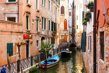 Narrow canal with boats in Venice, Italy
