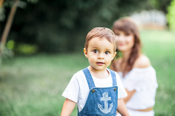 Mother and young son played on grass. Happy family walks in the Park. Mom and young son eating watermelon. Picnic. Summer.