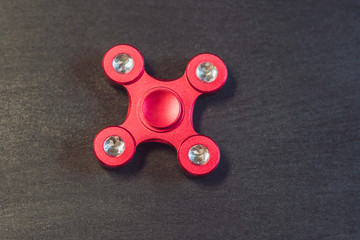 Famous fidget spinner stress relieving n a black wooden background