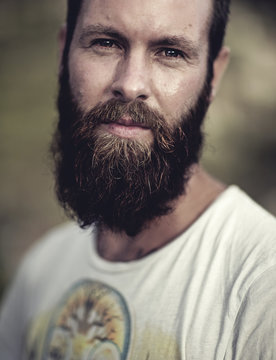Portrait of bearded man wearing printed T-Shirt, looking at camera.