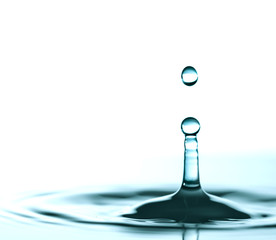 Water drop and splash on water surface on blue background