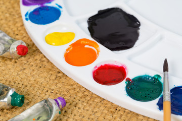 artists brushes and watercolour paints on palette.Used palette with paintbrush