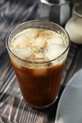 Glass with cold brew coffee and ice on wooden table