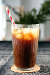 Glass with cold brew coffee and stand on blurred background