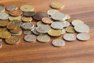 Different gold and silver collector's coins on the wooden table