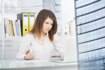 Young female designer using graphics tablet while working with computer