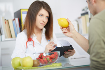 conceptual photo of a female nutritionist with fruits on the desk