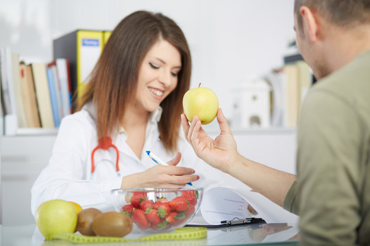 conceptual photo of a female nutritionist with fruits on the desk