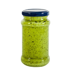 Pesto sauce in a glass jar isolated on white