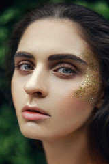 Brown eye surrounded by special golden elements. Cool make-up with black eyeliner, long eyelashes....