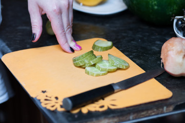 Chef's hands cut into zucchini