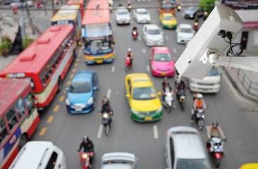 CCTV Security camera monitoring on street. Blurred traffic background.