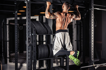 Strong man doing pull ups in gym - Powered by Adobe