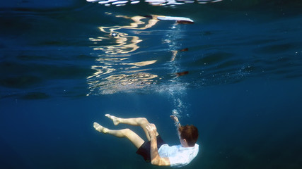 Fototapeta na wymiar young man sinking into the sea